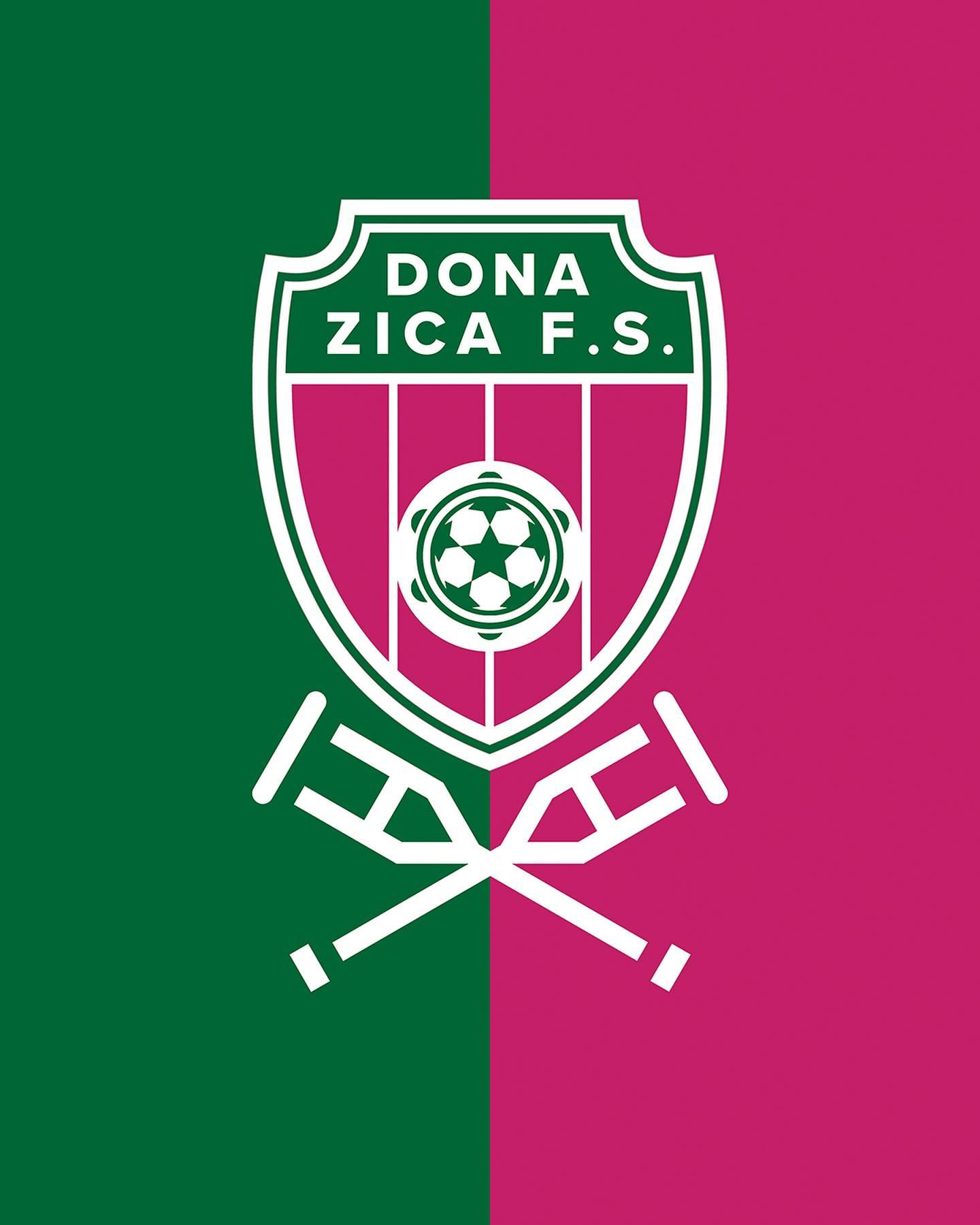 Novo escudo do Dona Zica F.S., em verde e rosa, com bola, pandeiro e muletas cruzadas.